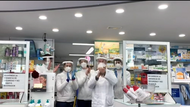 Trabajadores de una de las farmacias de Huesca con las pantallas de Luzán.
