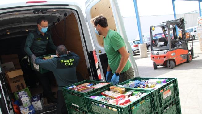 Agentes de la Guardia Civil entregan los productos recogidos para el Banco de Alimentos.