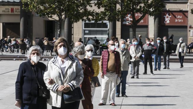 Gente con mascarilla haciendo fila para entrar en la basílica del Pilar de Zaragoza