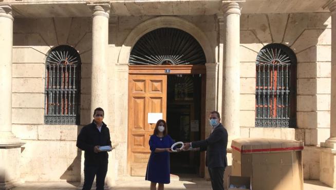 La alcaldesa, Emma Buj, y el primer teniente de alcalde, Ramón Fuertes, entregan el material al presidente de la CEOE, Ángel Muela.