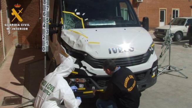 Los especialista de la Guardia Civil inspeccionan el vehículo que atropelló a la víctima.