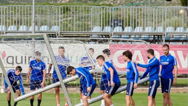Uno de los grupos de trabajo del Real Zaragoza, traslada una portería portátil en la Ciudad Deportiva durante una sesión de entrenamiento.