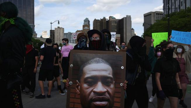 Un manifestante en Detroit con un cartel con el rostro de Georges Floyd, muerto a manos de la Policía,