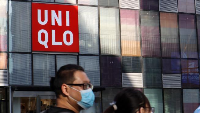 People walk past a store of the Fast Retailing's fashion chain Uniqlo, in Beijing