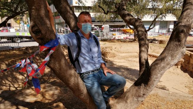 El portavoz de Podemos-Equo, Fernando Rivarés, encadenado a un olivo de la plaza Salamero.