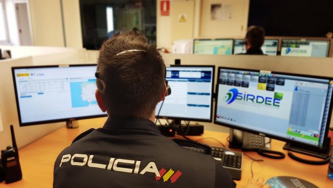 Un agente de la Policía Nacional ante varios ordenadores.