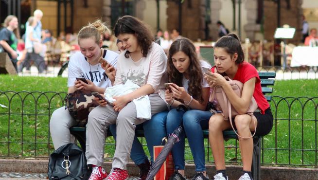 Grupo de adolescentes mirando el móvil.