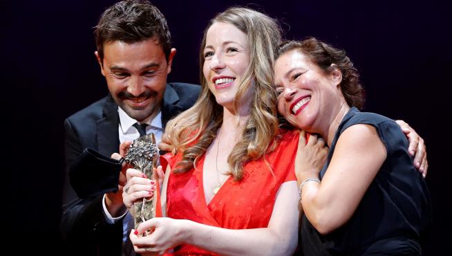 Pilar Palomero sostiene el galardón flanqueada por los productores de la película, Álex de la Fuente y Valeire Delpierre.