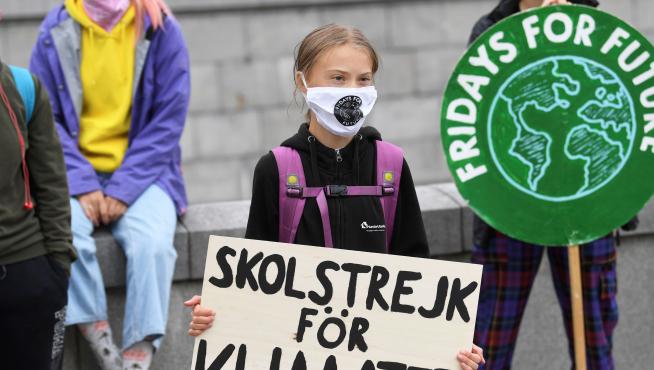 Greta Thunberg sostiene un cartel que dice 'Huelga escolar por el clima' durnate una protesta frente al Parlamento sueco, en Estocolmo.