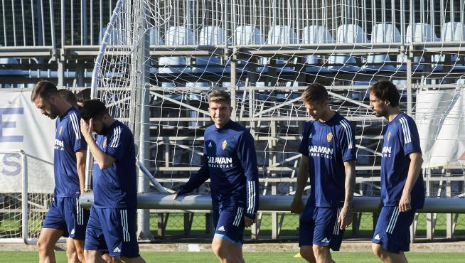 Varios jugadores del Real Zaragoza trasladan una portería en el entrenamiento de ayer.
