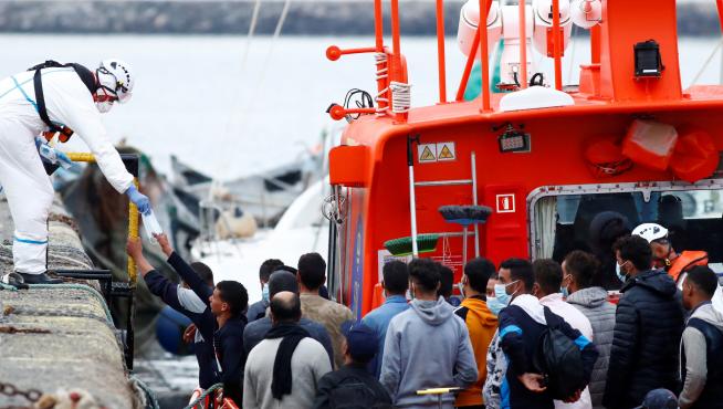 Un trabajador de Salvamento Marítimo reparte mascarillas en el puerto de Arguineguín, en Gran Canaria.