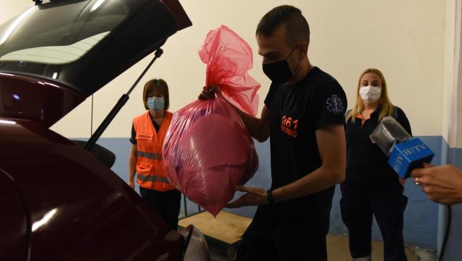 Un equipo del 061 carga el material en el coche para trasladarse al primer colegio del día.