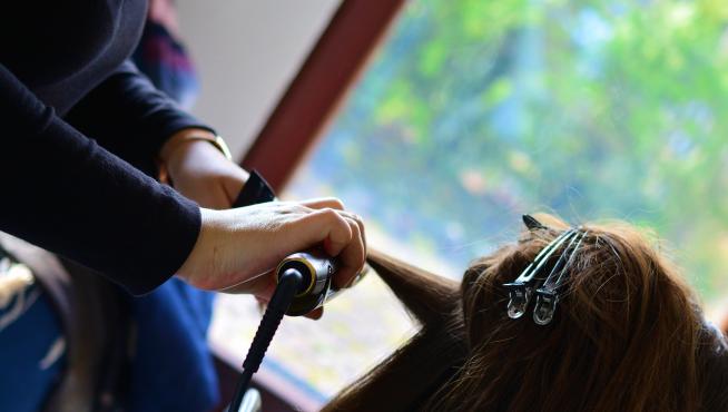 Imagen de una peluquera peinando a una clienta.