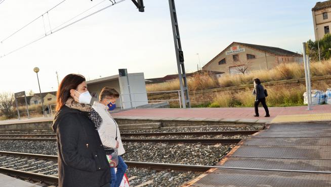 Dos pasajeras van a cruzar la vía para coger el tren en dirección a Zaragoza.