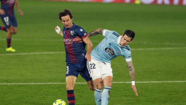 El jugador del Celta de Vigo Santi Mina , pugna por un balón, con el jugador del Huesca Mosquera