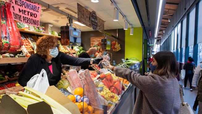 Una consumidora adquiere fruta en un puesto del Mercado Central de la capital aragonesa.