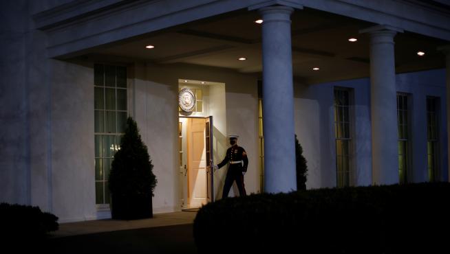 A U.S. Marine opens a door of the West Wing door, an indication that U.S. President Donald Trump is in the Oval Office during his last day in office, in Washington U.S.