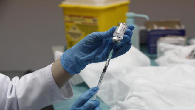 Extracción del líquido del vial para proceder a vacunar.