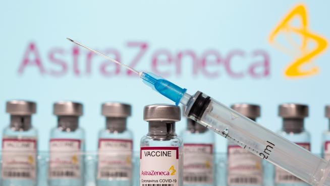 FILE PHOTO: Vials labelled "AstraZeneca COVID-19 Coronavirus Vaccine" and a syringe are seen in front of a displayed AstraZeneca logo