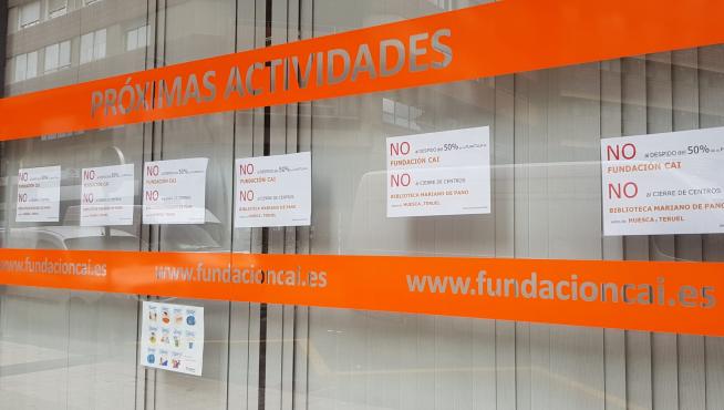 Trabajadores de la Fundación CAI han puesto cartelers contra los planes de recorte de empleo en la biblioteca Mariano de Pano.