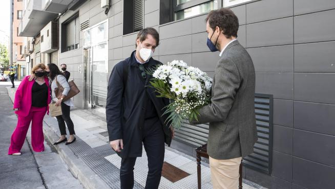 Borja Giménez, con un ramo de flores, y su hermano Manuel, ante la palca que recuerda el asesinato de su padre en la calle Cortes de Aragón el 6 de mayo de 2001.