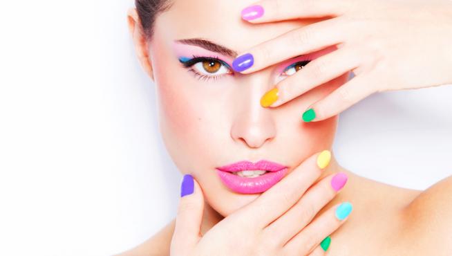 Mujer con manicura especial con uñas de colores distintos