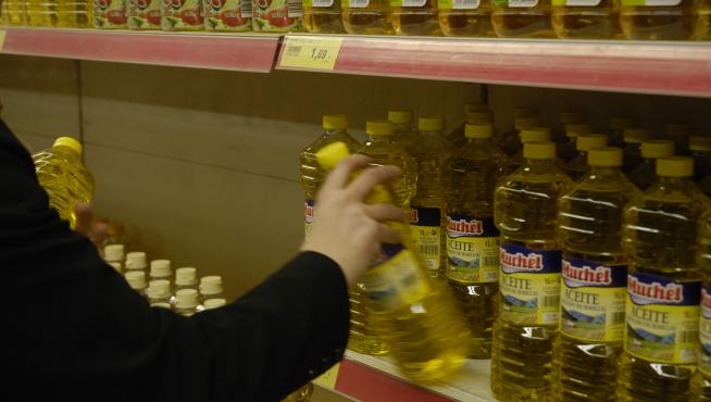 Imagen de archivo de una estantería con botellas de aceite en un supermercado,