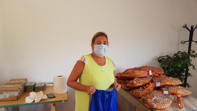 Pilar Molina, alcaldesa de Allueva, junto a los jamones que se han regalado a sus vecinos.