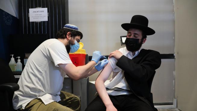 Un enfermero israelí inocula con la tercera dosis de la vacuna a un ciudadano