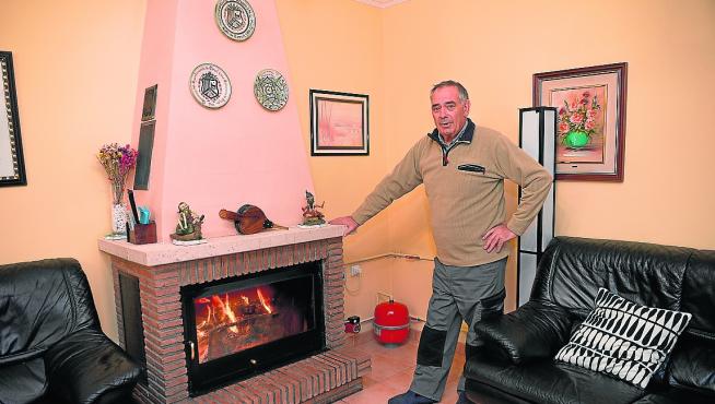 Ramón Navarro, junto a la chimenea de leña que ha instalado en su casa de Villaspesa.