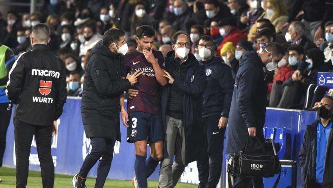 Florian Miguel se retira del campo acompañado por el doctor Sarasa durante el partido con el Girona del domingo.