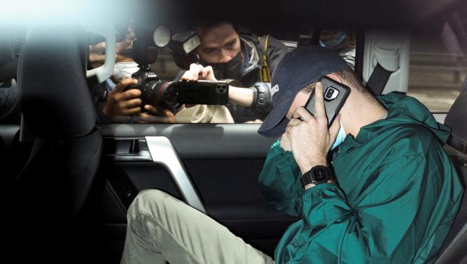 Members of the media photograph an unidentified man departing the car park at the offices of Serbian tennis player Novak Djokovic's legal team under police escort in Melbourne, Australia, January 15, 2022. REUTERS/Loren Elliott TENNIS-AUSTRALIA/DJOKOVIC