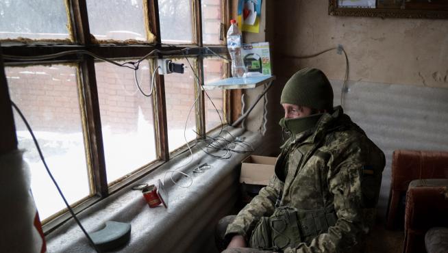 Un soldado ucraniano ve la tele en un móvil mientras en la ciudad de Avdiivka. UKRAINE RUSSIA CRISIS