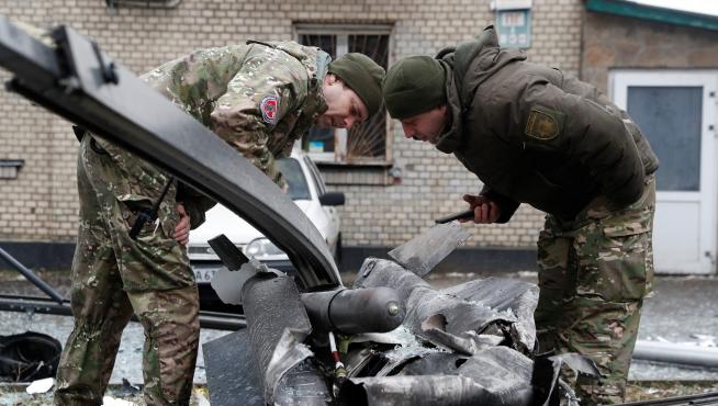 Policias ucranianos inspeccionan los restos de un misil en las calles de Kiev.
