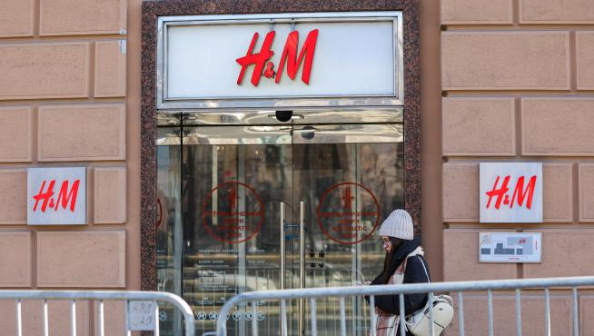 A woman walks past a closed H&M store in Moscow