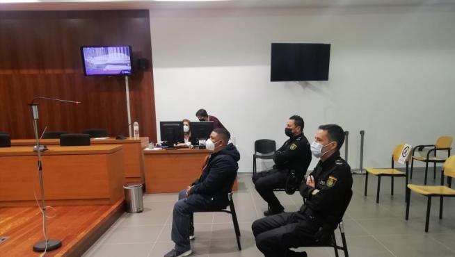 El acusado, escoltado por dos policías, durante el juicio celebrado en la Audiencia de Zaragoza.
