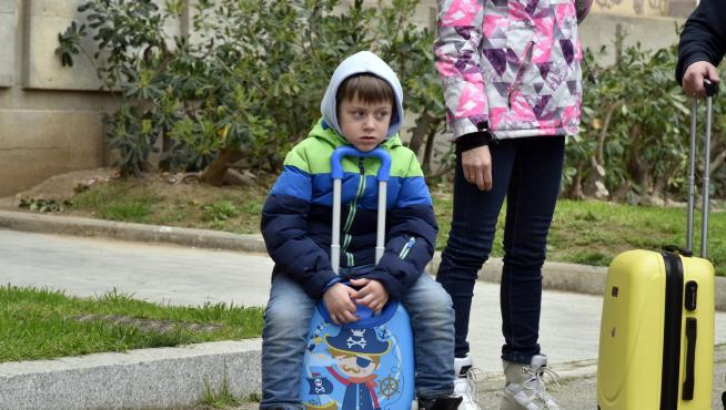 Un niño refugiado descansa sobre su maleta tras llegar a España.