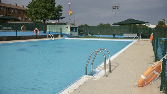 La piscina de Almudévar permanecía cerrada por la tarde, por las tormentas. Al fondo, la caseta de las instalaciones.