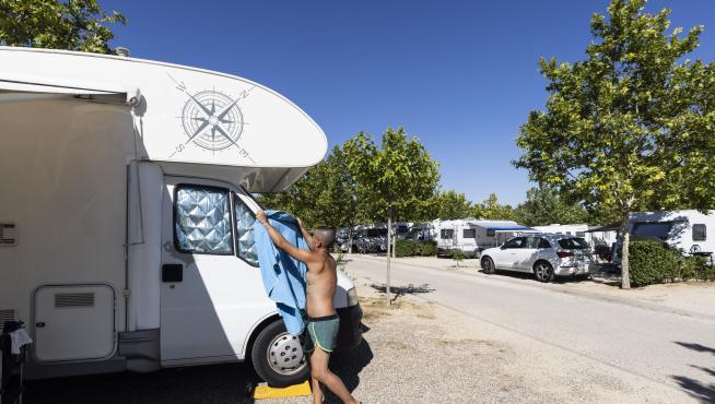 Un huésped del Camping Municipal de Zaragoza, ayer, junto a una caravana.