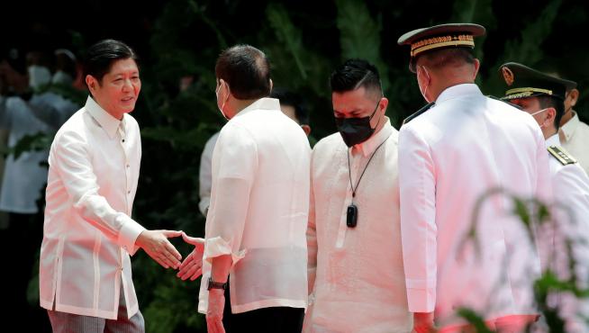 Ferdinand Marcos Jr estrecha la mano de Duterte, el presidente saliente