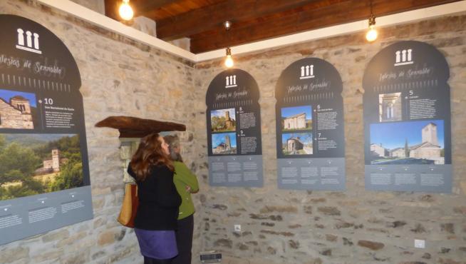 Dos visitantes leen los paneles en una de ofertas culturales: Iglesias del Serrablo