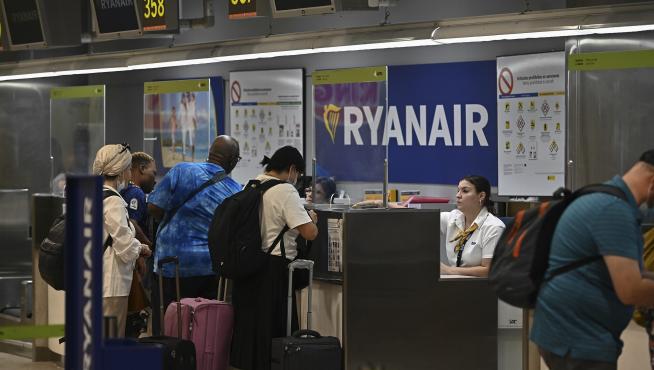 Varios pasajeros facturan sus maletas en los mostradores de Ryanair.