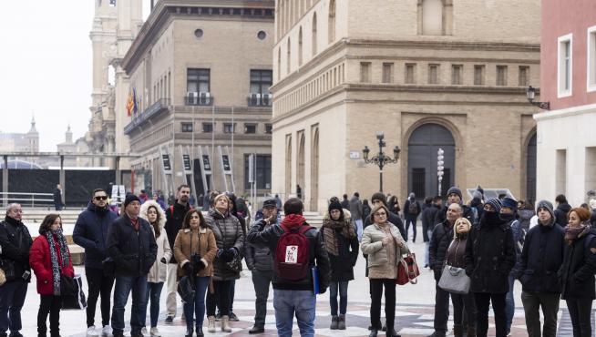 Un grupo de turistas con guía en la plaza del Pilar de Zaragoza.