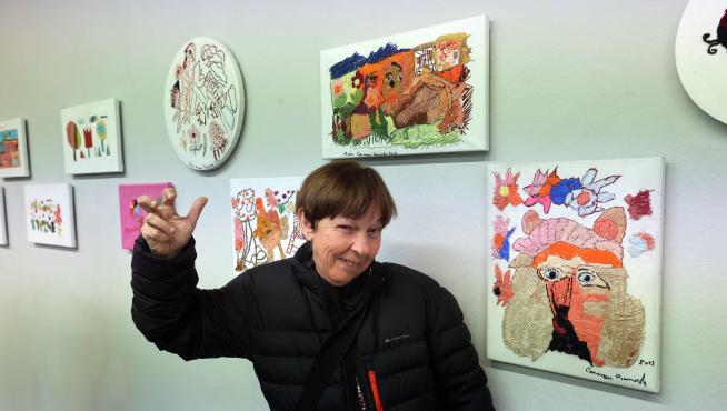 Una de las 16 artistas, Carmen Bonacho, junto a sus obras, en la sala del Centro Cultural Manuel Benito Moliner donde se exhibe la exposición 'Bordado sobre lienzo'.