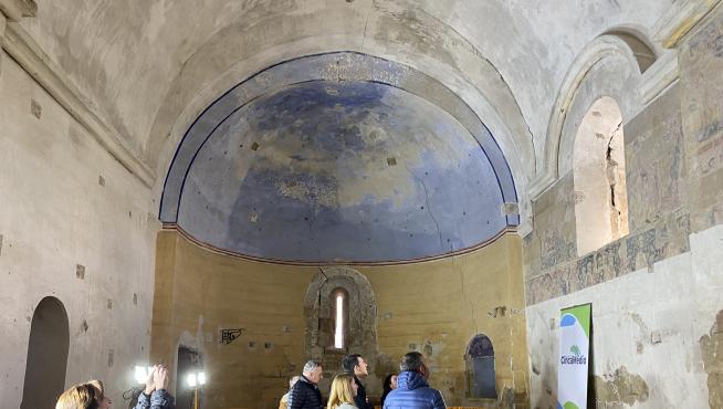 Autoridades y vecinos observan las pinturas murales templarias de Cofita