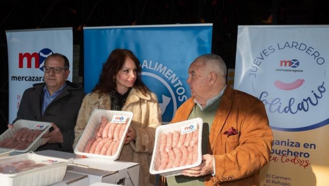 El presidente del Banco de Alimentos, José Ignacio Alfaro; y la concejal delegada de Mercados, Carmen Herrarte, en la entrega de 580 raciones de longaniza en Mercazagoza para celebrar el Jueves Lardero.