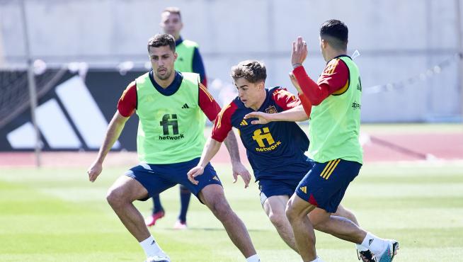 Los centrocampistas de la selección española Rodri Hernández (i) y Pablo Gavi (c) participan en el entrenamiento del combinado nacional.
