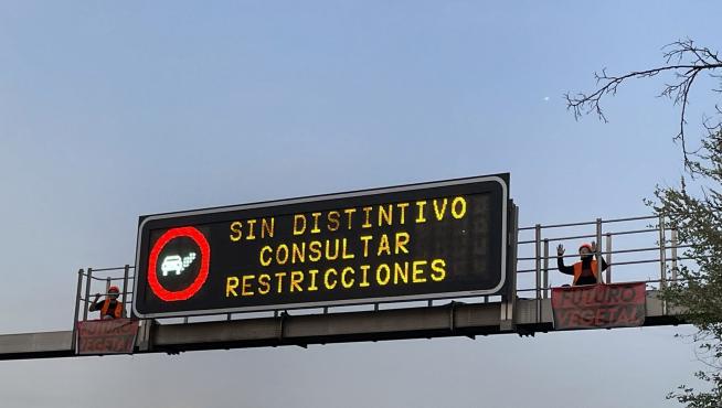 Dos activistas de Futuro Vegetal junto al cartel luminoso de la M-30.