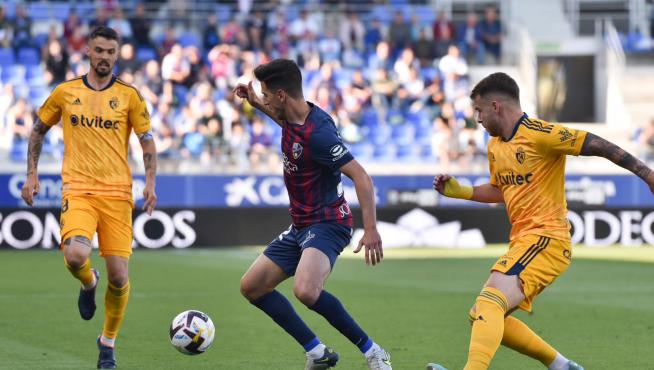 Juan Carlos controla el balón rodeado de dos rivales