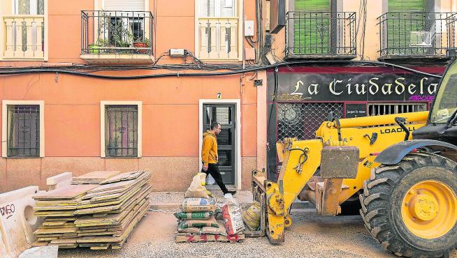Un vecino camina por la acera frente a material de obra en la calle de Concepción Arenal de Zaragoza